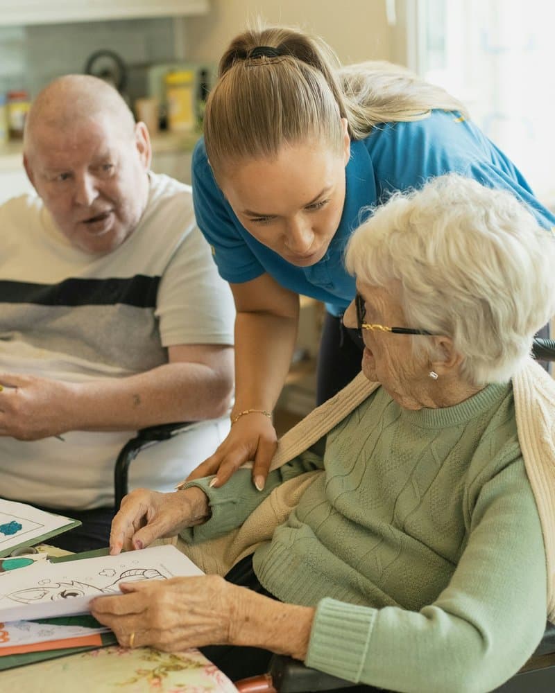 A caregiver sharing a warm moment with a senior client in a bright, comfortable home